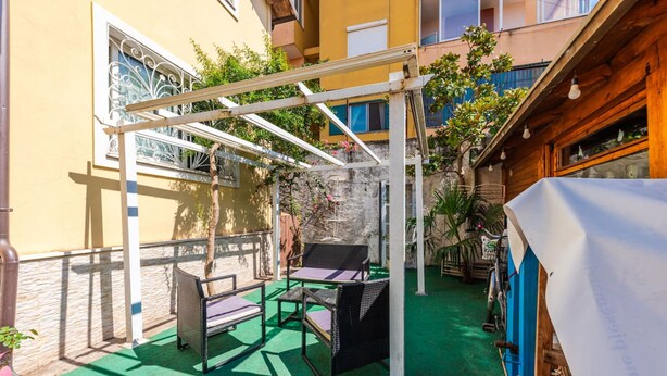 An outdoor patio with a pergola, two wicker chairs, and a table. - Guesthouse 'hapa të Lehtë' - Room 1 - Pro Bono (Shkodër)