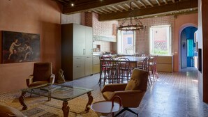 A spacious living room with a dining area, a kitchen, and a view of the outside. - Bella Vista Duomo - Luxury Apartment in Lucca (Lucca)