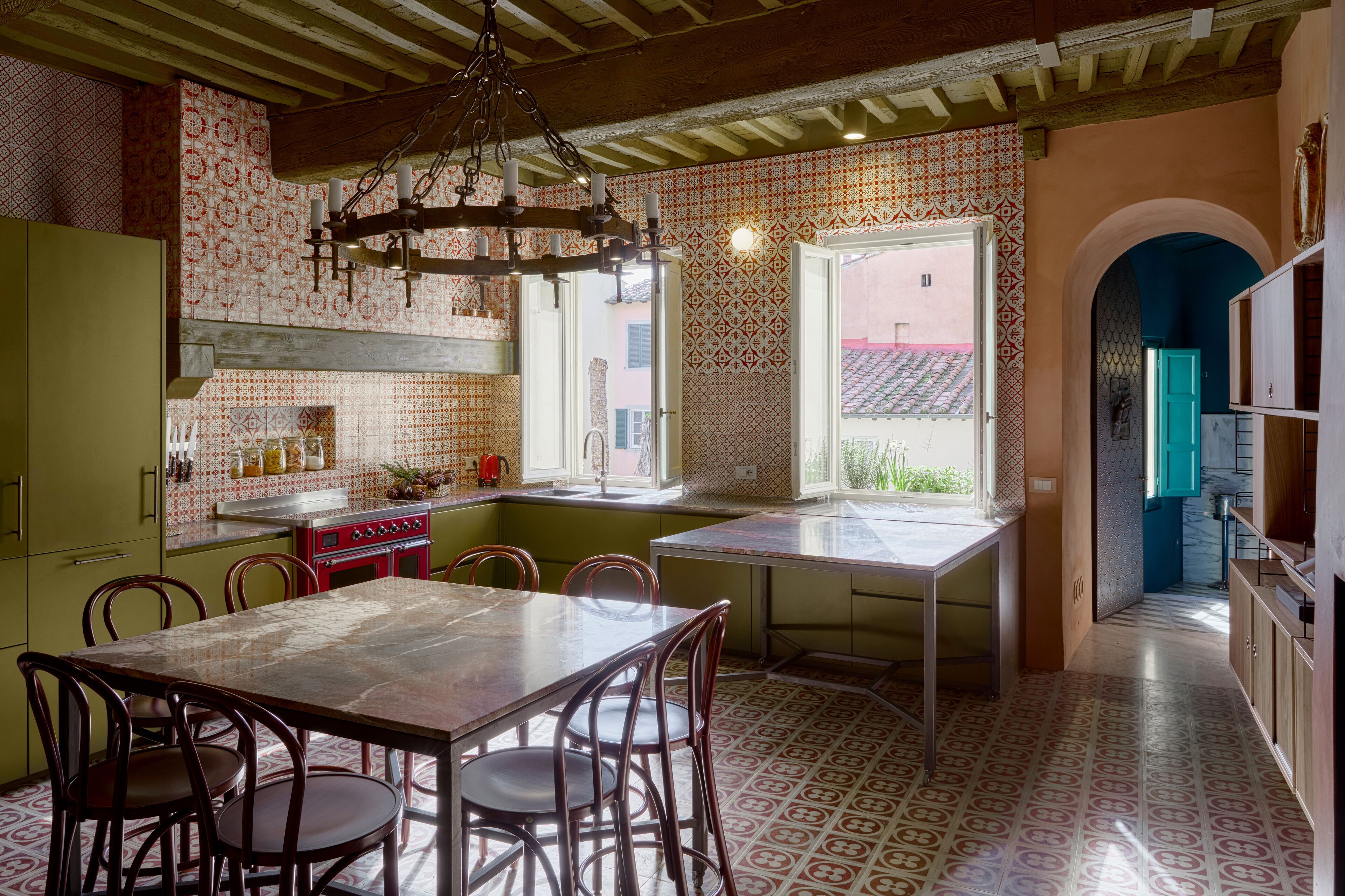 Una cocina con mesa, sillas y una araña.