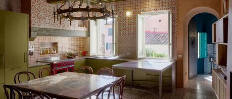 Una cocina con mesa, sillas y una araña.