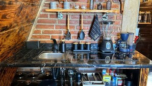 Una cucina con parete in mattoni, mobili in legno e diversi utensili da cucina.