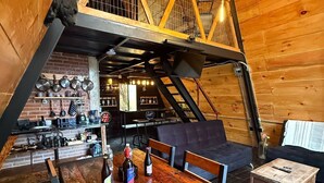 Un interno rustico in legno con zona pranzo, angolo cottura e area relax.