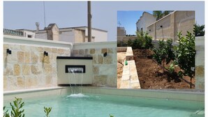 A swimming pool with a waterfall feature, surrounded by stone walls and greenery. - Villa Romolo with swimming pool 150 mt from the Caribbean beach of San Pietro (San Pietro In Bevagna)