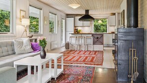 A modern kitchen with a large stove, white cabinetry, and a view of the outdoors.