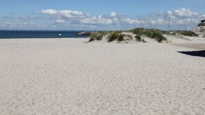 A sandy beach with dunes and a clear sky.