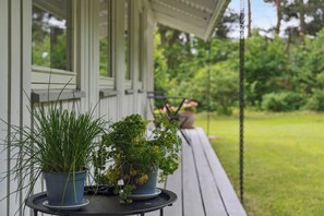 Eine Veranda mit Blumentöpfen und einem Tisch.