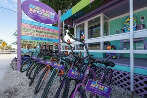 Un edificio colorido con un cartel que enumera servicios como alquiler de kayaks y artículos de regalo y de playa.