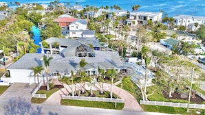 A coastal residential area with houses, a swimming pool, and a view of the ocean. - One Of The Most Unique Homes in Anna Maria Island (Holmes Beach)