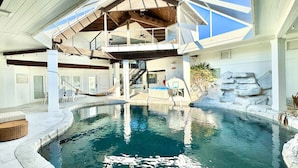 A swimming pool with a wooden deck, a hot tub, and a staircase leading to a balcony. - One Of The Most Unique Homes in Anna Maria Island (Holmes Beach)