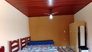 A bedroom with a wooden ceiling, a bed with a floral bedspread, a wardrobe, and a ceiling fan. - Santa Maria da Serra Farm, sleeps up to 2 people (Maria vitoria 1 Dois Córregos)