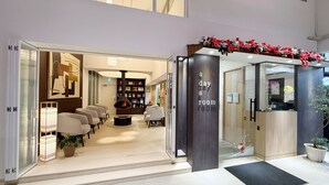 A modern hotel lobby with a fireplace, seating area, and a 'a day a room' sign. - A Day A Room (Taichung)