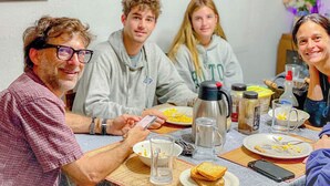 A dining table with plates, glasses, and a thermos.