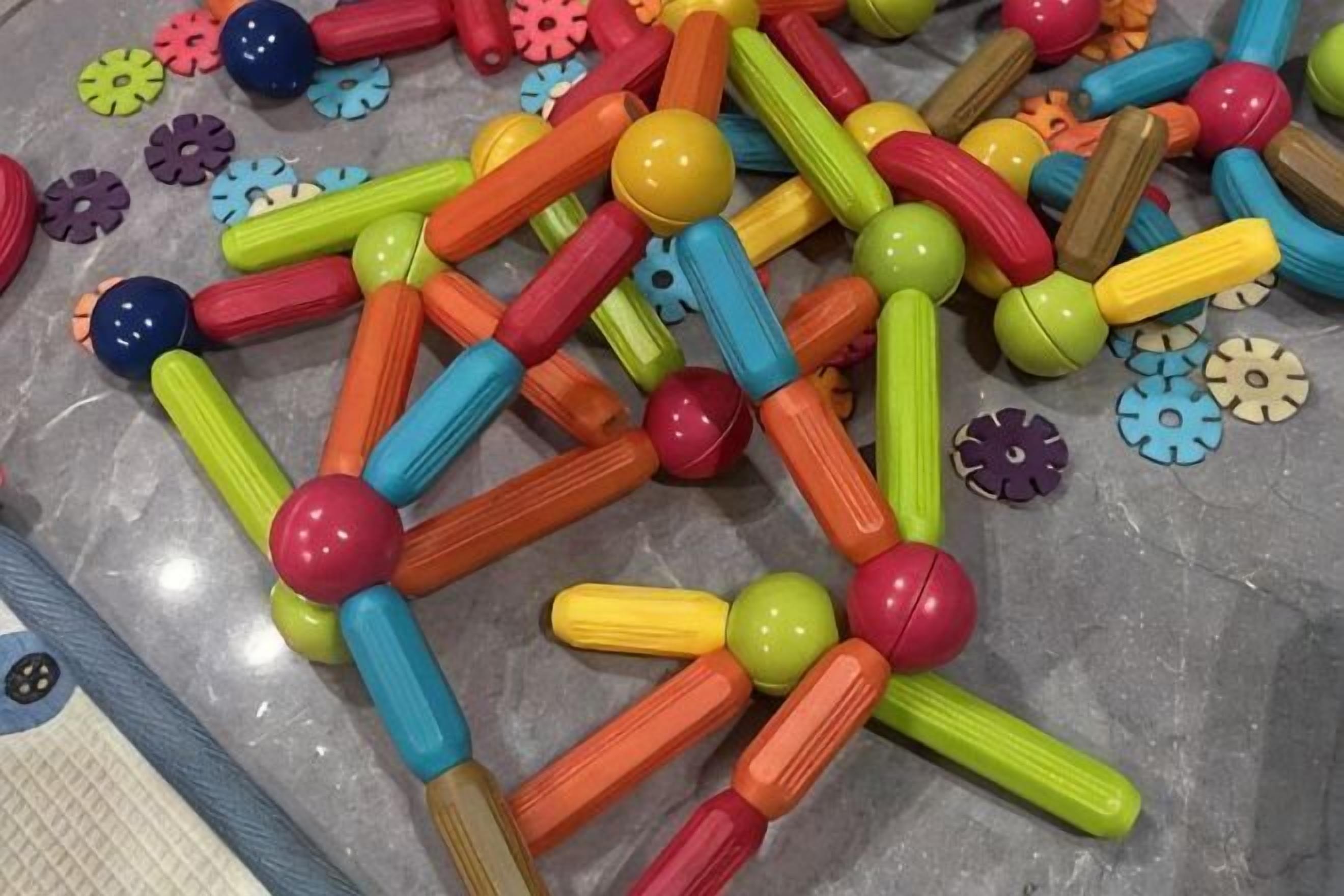 Una colección de piezas de juguete de plástico de colores sobre el suelo.