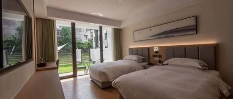 A modern hotel room with two beds, a desk, and a large window.