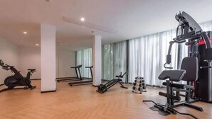 A spacious gym with cardio equipment, weight machines, and free weights. - Nanxi River Lion Crag Hotel (Yongjia)