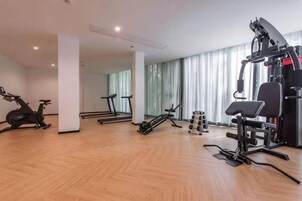 Un gimnasio amplio con equipo de cardio, máquinas de pesas y pesas sueltas.