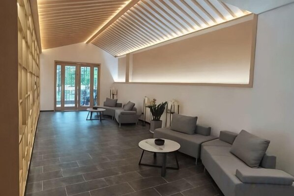 A modern interior with a sectional sofa, a coffee table, and a large window with a view.