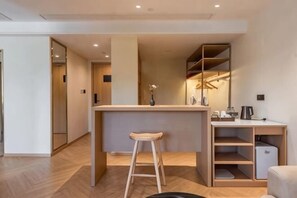 A modern kitchen with a bar area, wooden flooring, and built-in shelving. - Nanxi River Lion Crag Hotel (Yongjia)