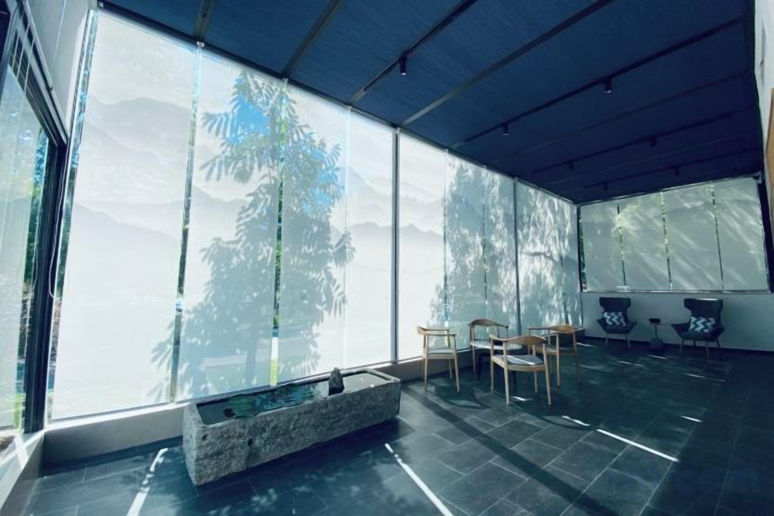 Un interior modern amb una finestra gran, una font de pedra i seients.