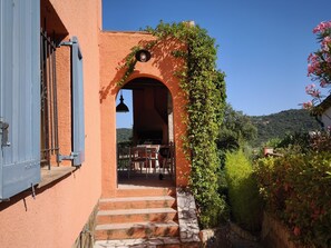 A building with a stone staircase leading to an outdoor seating area with tables and chairs.