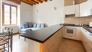 Une cuisine moderne dotée d’un îlot central, de meubles blancs et d’un plafond en bois.
