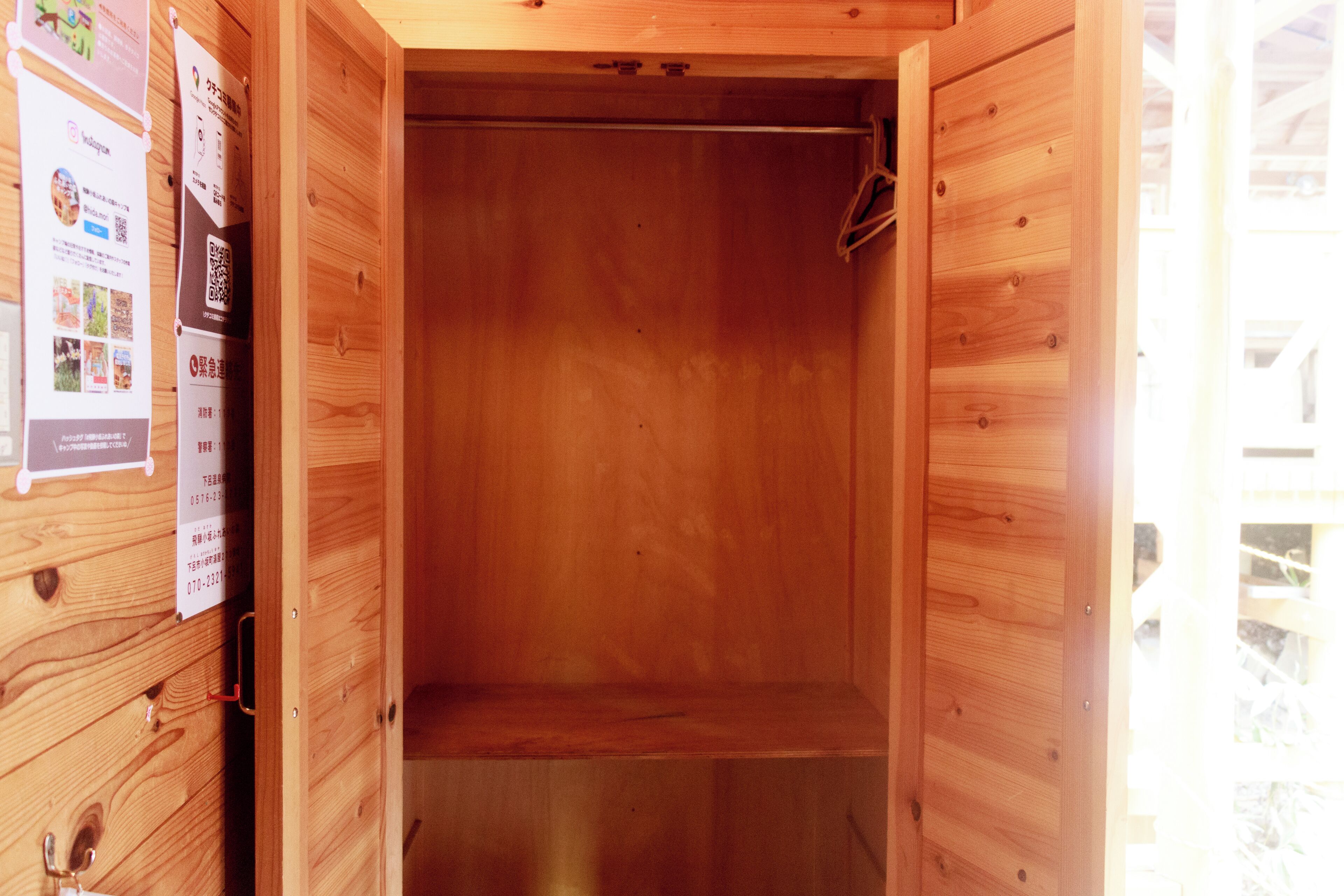 A wooden interior with a metal shelf, wooden walls, and a door.
