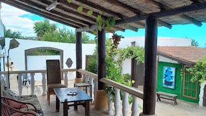 A covered patio area with a table and chairs, a railing, and potted plants. - Boliqueime Villa Private Pool With Ocean View (Loulé)