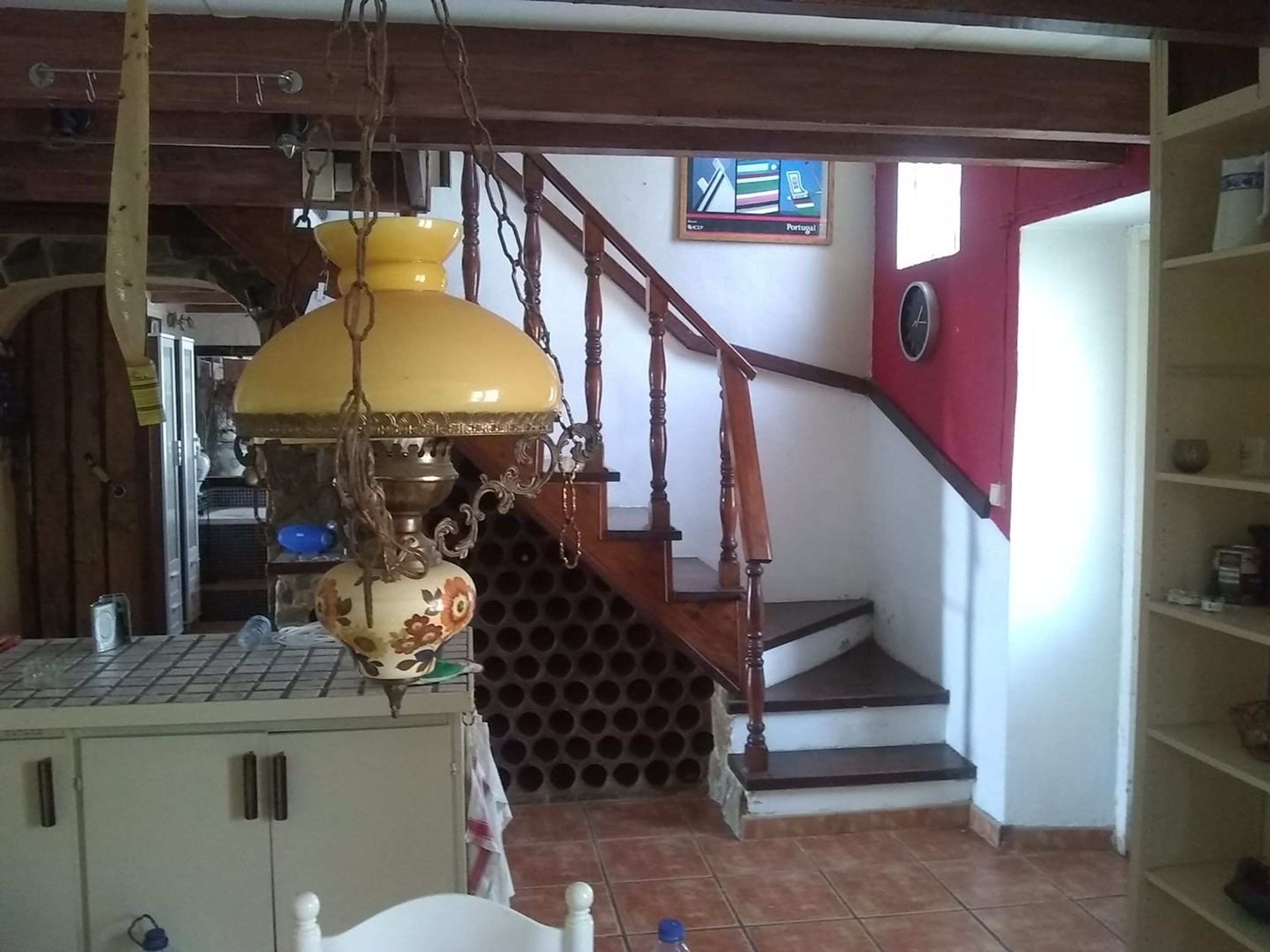 Un escalier avec des rampes en bois et un mur rouge.