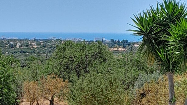 A pool with a white balustrade, a red lounge chair, and a view of the sea and distant landscape. - Boliqueime Villa Private Pool With Ocean View (Loulé)