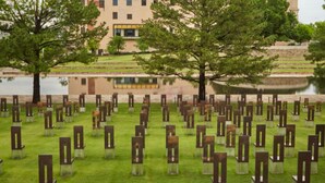 A memorial with benches and a building in the background. - Fully-furnished Studio With Rustic Design 36B (Oklahoma City)