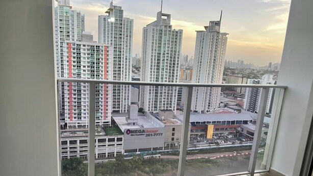 A balcony with a cityscape view, including high-rise buildings and a parking area. - Cozy apartment in Panama (Panamá)