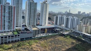 A high-rise residential building with a parking garage and a commercial building with a sign for MEGA Storage. - Cozy apartment in Panama (Panamá)