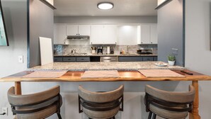 A modern kitchen with a central island, white cabinets, and stainless steel appliances. - Spacious 8BR Modern Retreat Pool Table RV (Bethany)