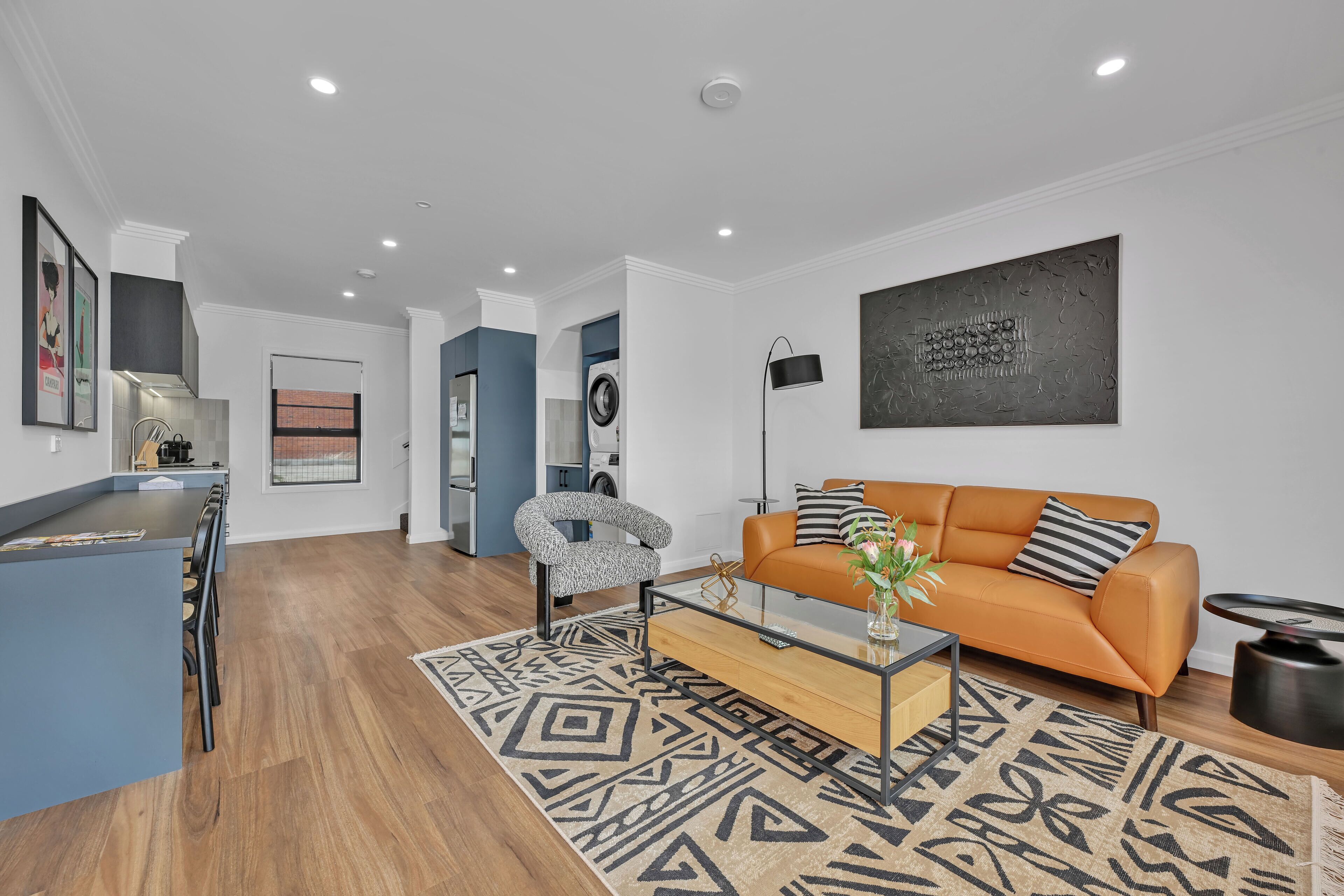 A modern living room with a sofa, coffee table, and patterned rug.