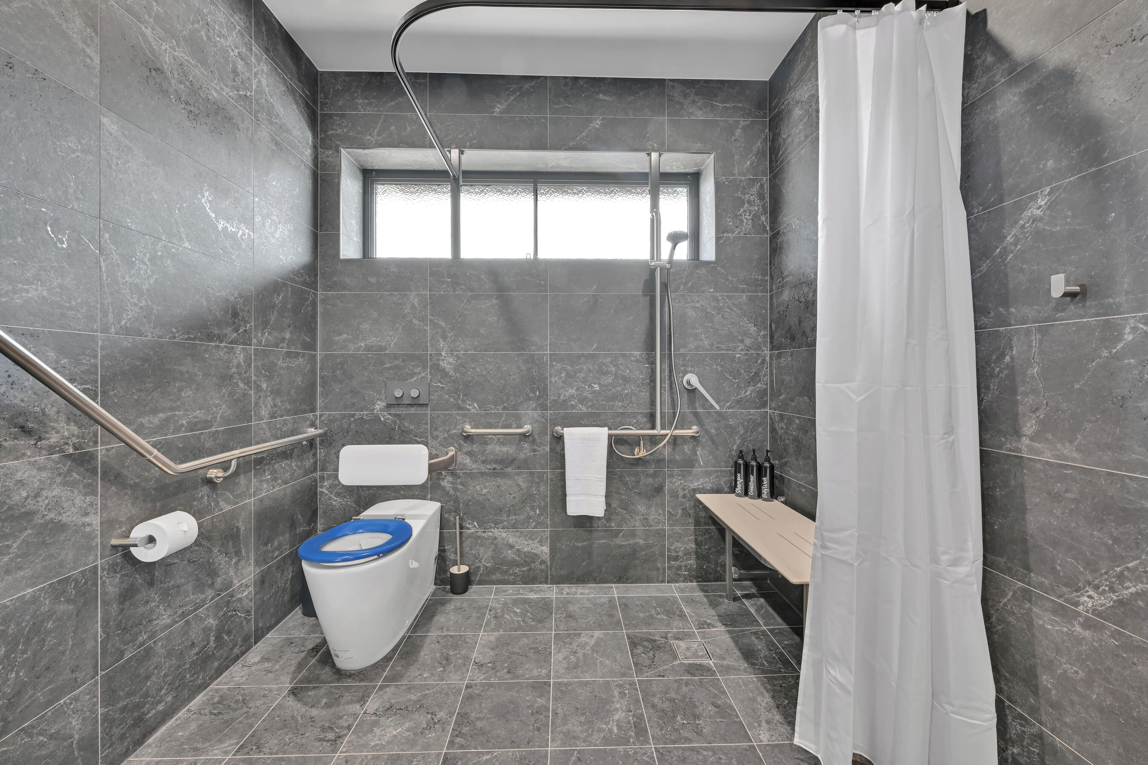 Une salle de bain moderne équipée d’une douche, de toilettes et d’un lavabo.