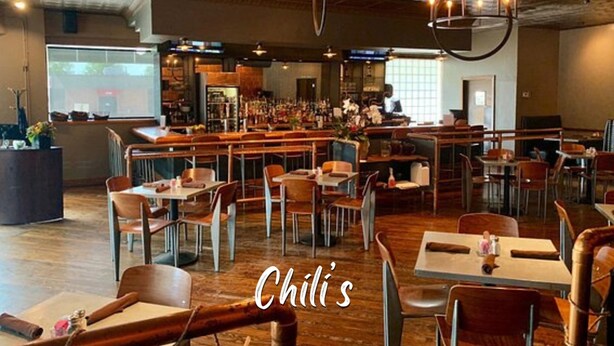 A restaurant interior with wooden tables and chairs, a bar area, and a modern chandelier. - Comfortable 6BR Urban Retreat Lgbtq 38 (Oklahoma City)