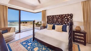 Une chambre spacieuse avec un grand lit, une vue sur la plage et un balcon.