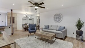 A modern living room with a grey sofa, a wooden coffee table, and a blue armchair. - Beautiful condo in central Scottsdale (Scottsdale)