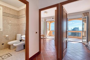 Ein Hotelzimmer mit Bad, einem Balkon mit Aussicht und einer Tür zu einem weiteren Zimmer.