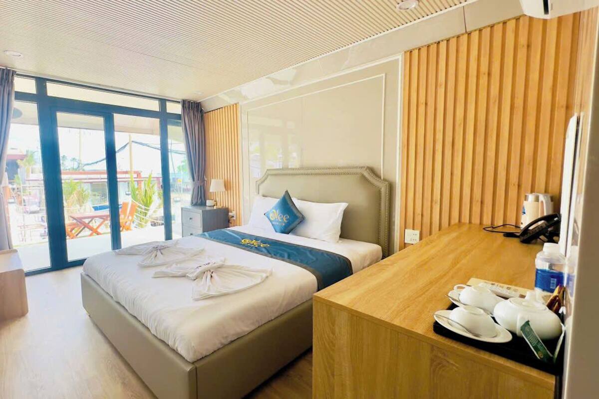 Quarto de hotel com uma cama, uma escrivaninha e vista para o exterior.