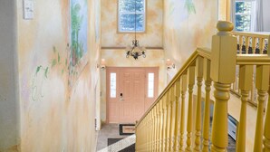 A staircase with a yellow railing leading to a door with a window above it. - Aurora Panorama Lodge- Perfect Retreat 5b3b (Fairbanks)