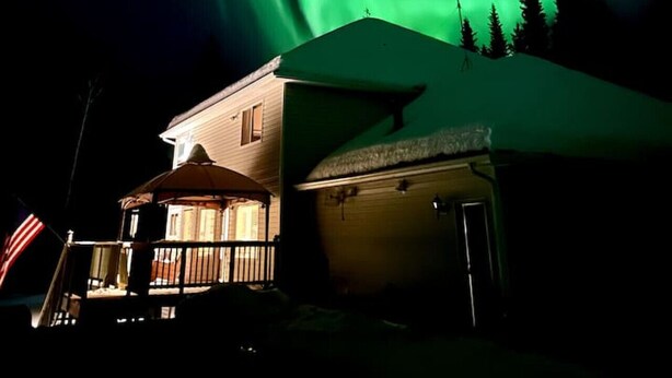 A house with a snow-covered roof and a visible garage door. - Aurora Panorama Lodge- Perfect Retreat 5b3b (Fairbanks)
