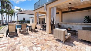 Une terrasse extérieure avec une piscine, des chaises longues et un espace repas.