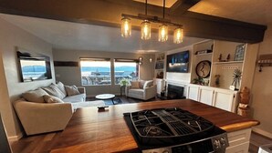 A modern kitchen with a central island, built-in oven, and a dining area with a view. - Charming 3-bedroom lake view home in tranquil Coeur d'Alene (Coeur d'Alene)