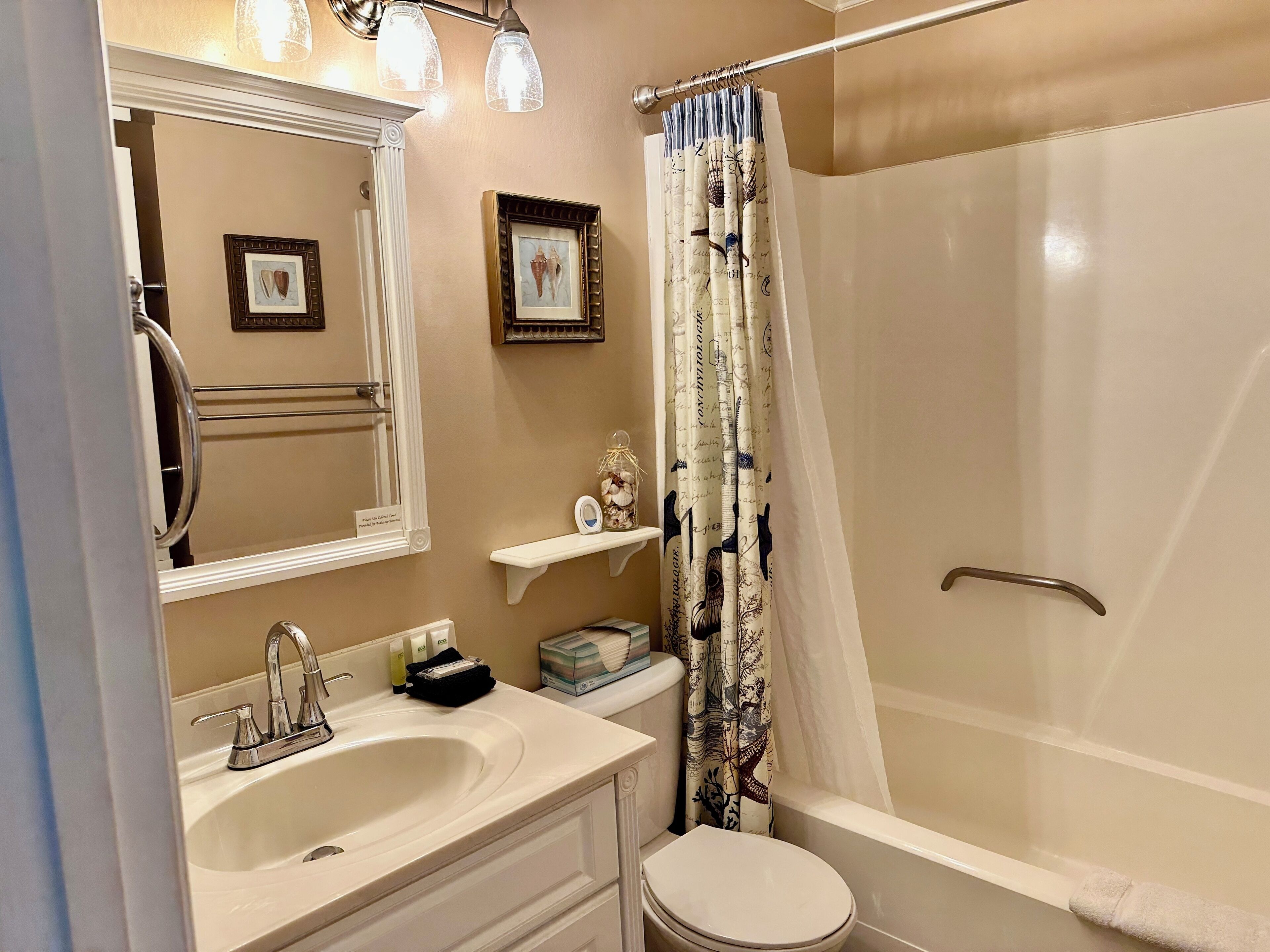 A bathroom with a sink, mirror, toilet, and shower.