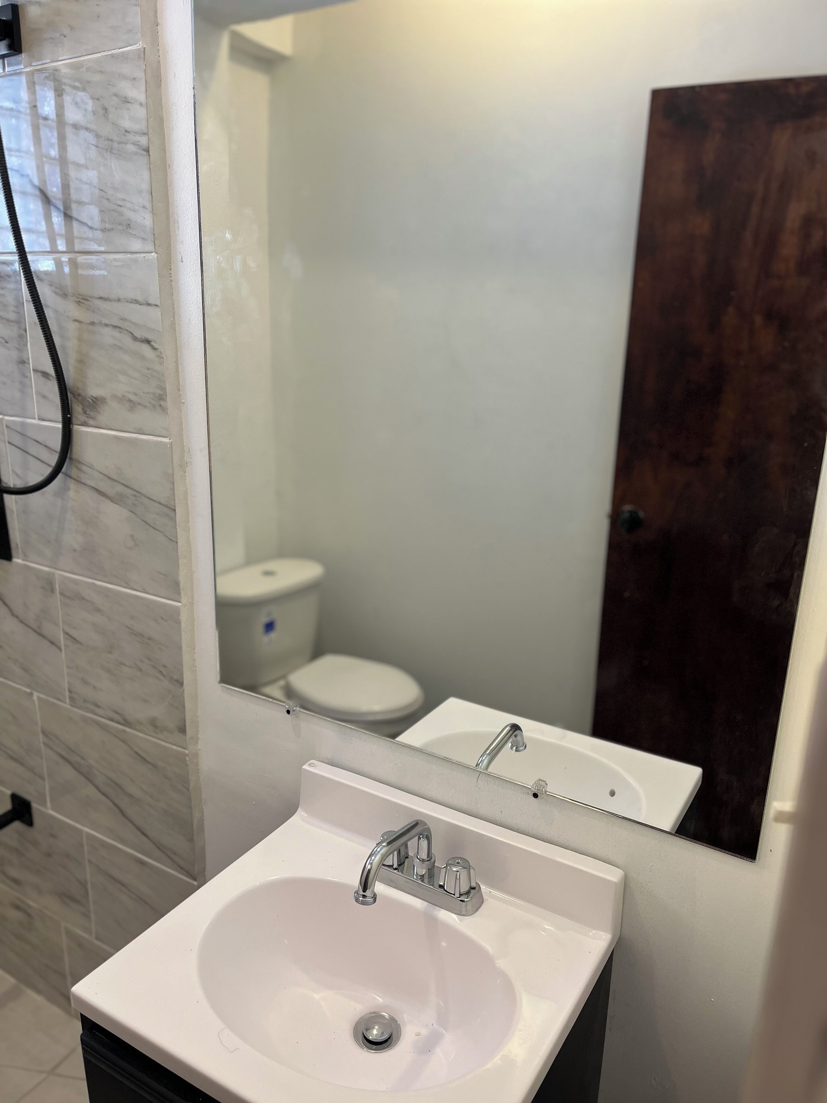 A bathroom with a white sink, a mirror, and a shower.