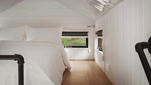 Un dormitorio con cama, ventana y radiador.