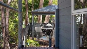 A covered outdoor area with a grill and seating, surrounded by trees. - Kingfisher Loft – 2BR Spa Bath Retreat near Daylesford & Hepburn Springs (Daylesford)