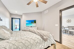 Relax in a serene bedroom with a large bed, ceiling fan, and flat-screen TV.