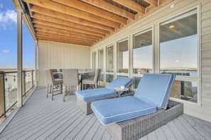 Relax in a serene outdoor space with a wooden deck, lounge chairs, and a small table.